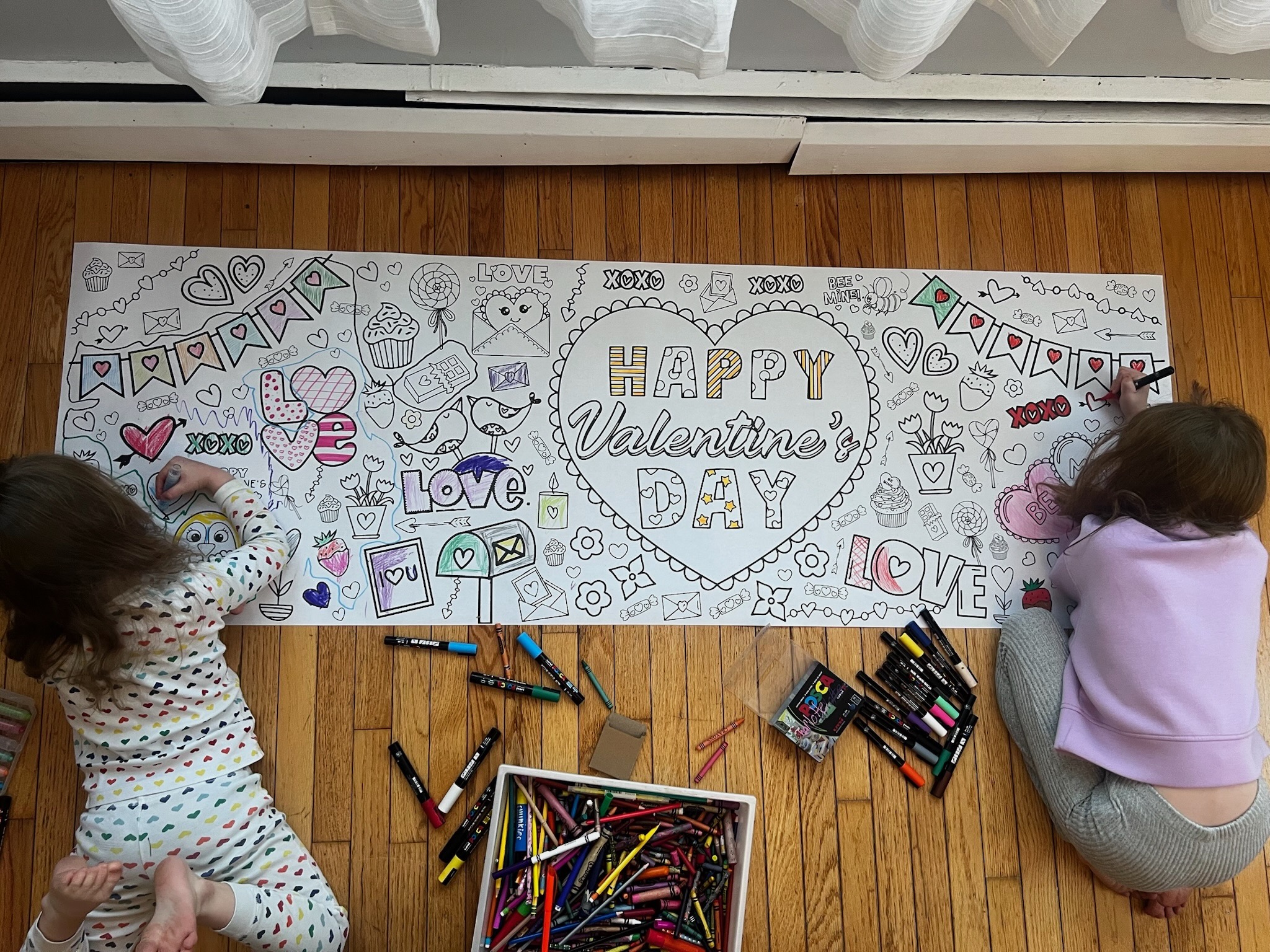 Kids coloring a MyLittlePicassos banner together as a thoughtful gift idea