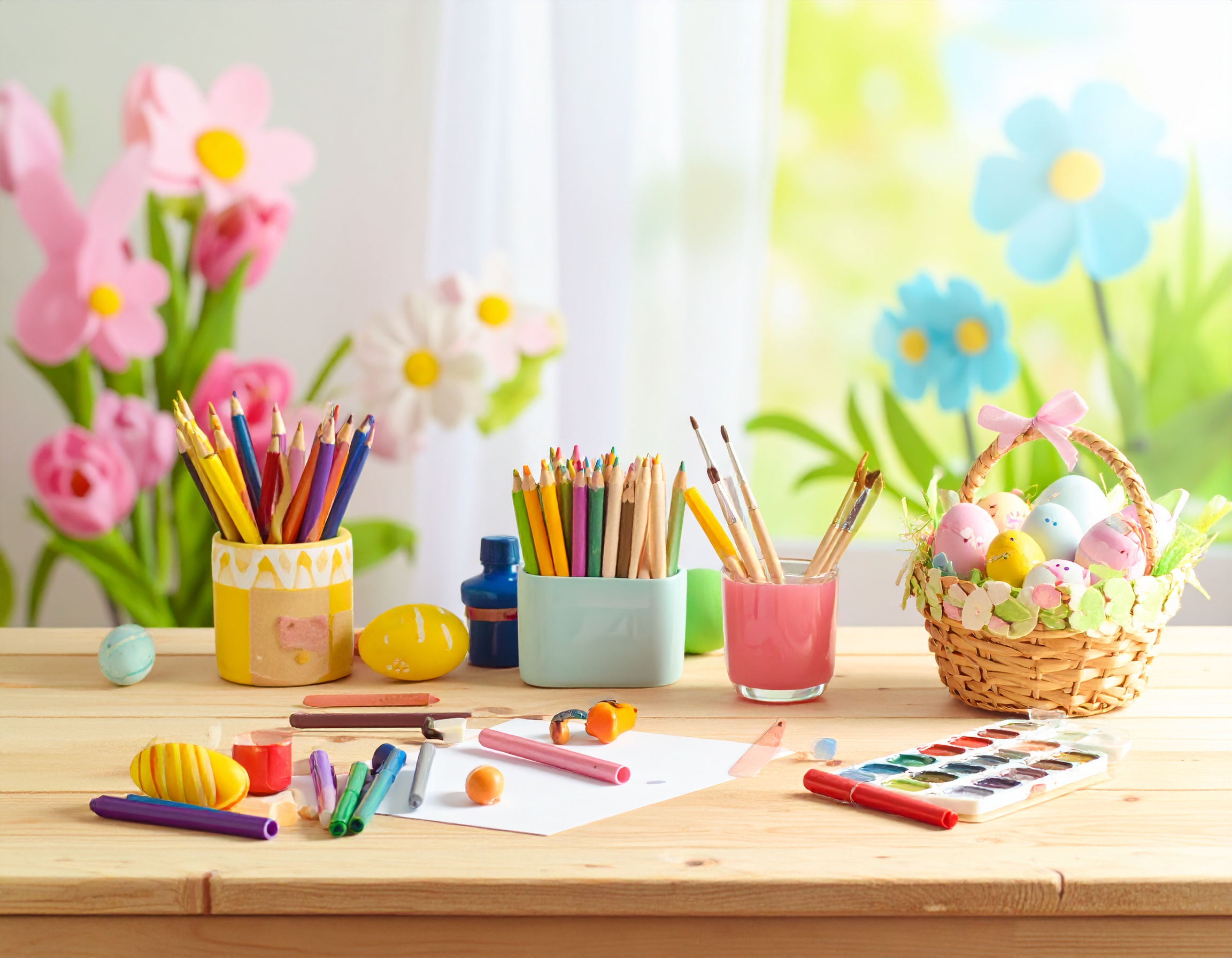 Easter activity table with colored pencils, paint supplies, and a basket of pastel eggs for kids’ spring crafts